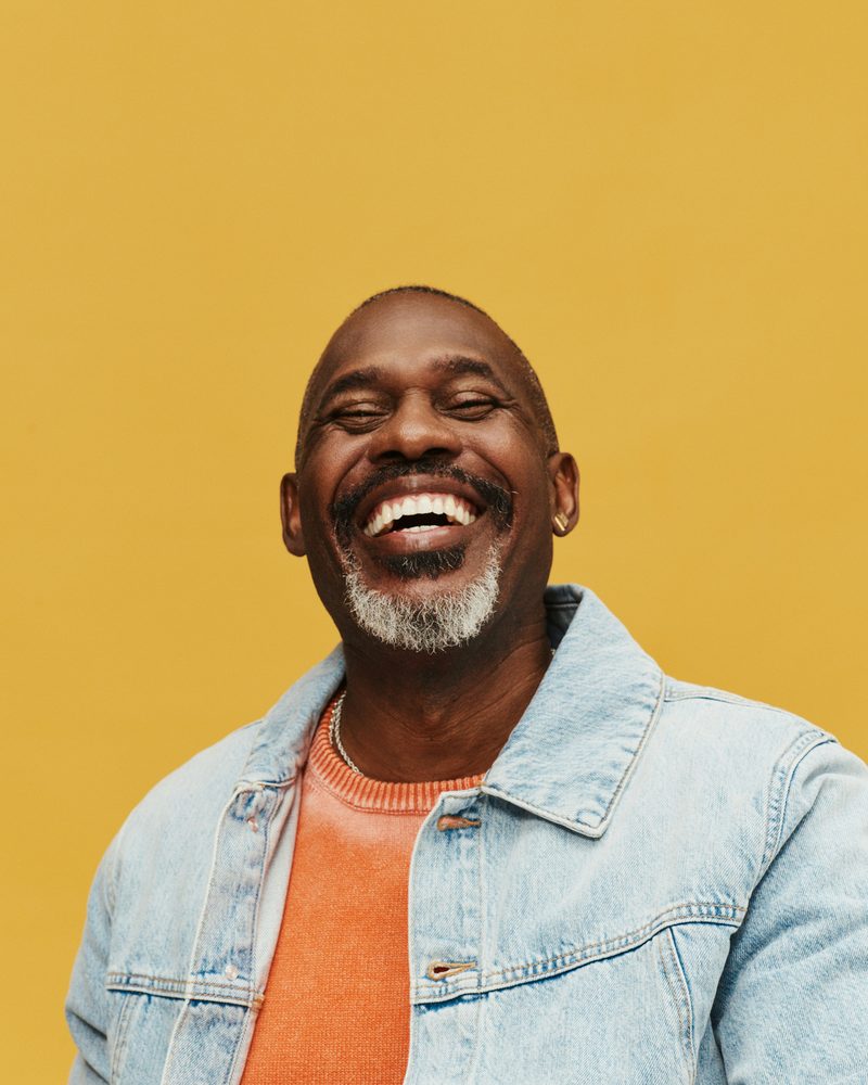 A smiling man in a denim jacket