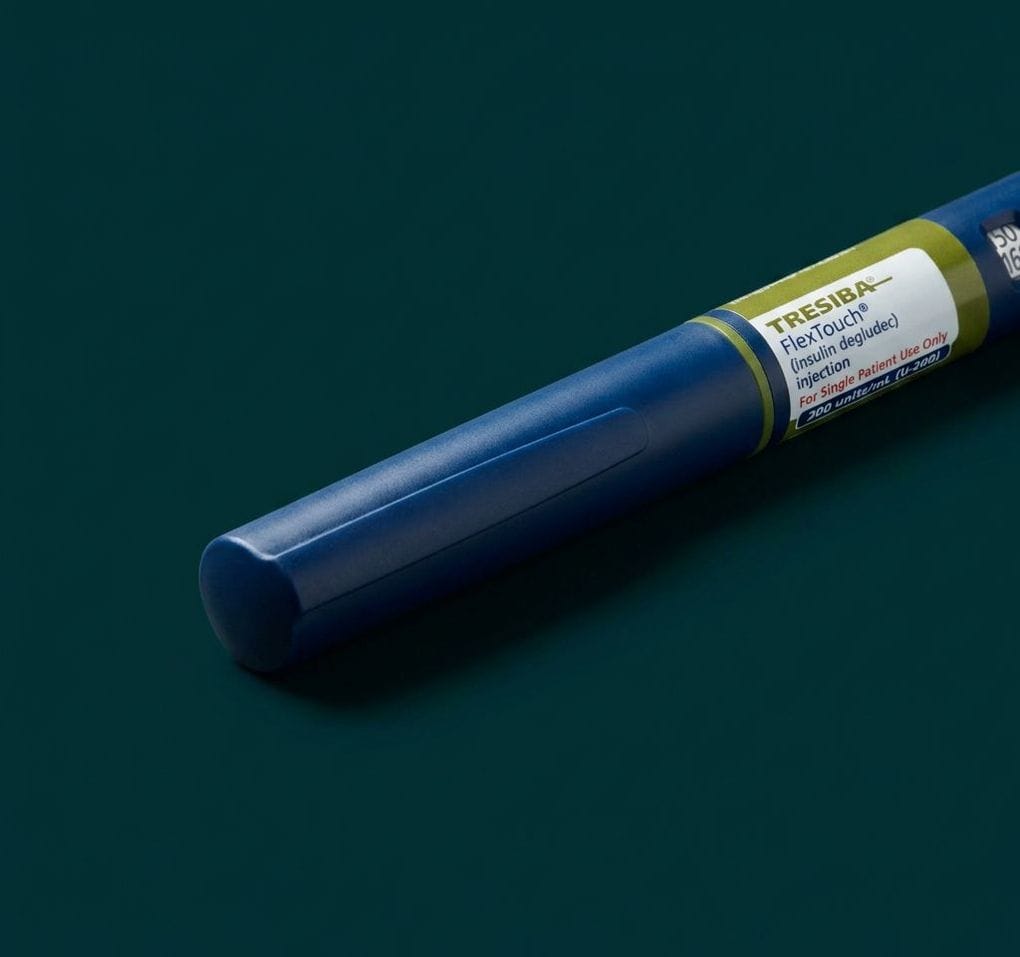 Navy Tresiba FlexTouch pen lying on a deep teal surface